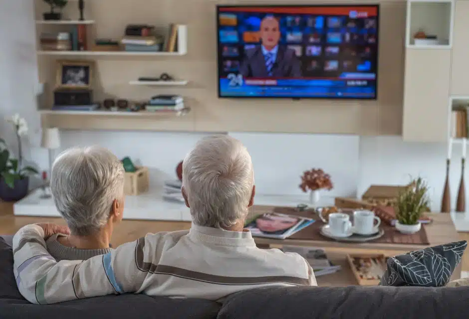 Couple de résidents seniors regardant la télévision dans une maison de repos