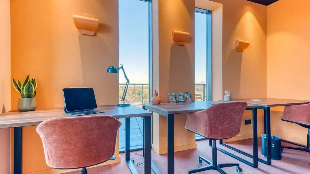 Salle de Coworking avec des murs oranges de l'Hôtel MAH