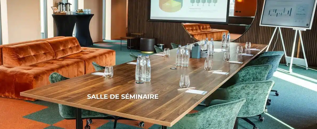 Salle de séminaire élégante avec une grande table en bois, des chaises en velours vert