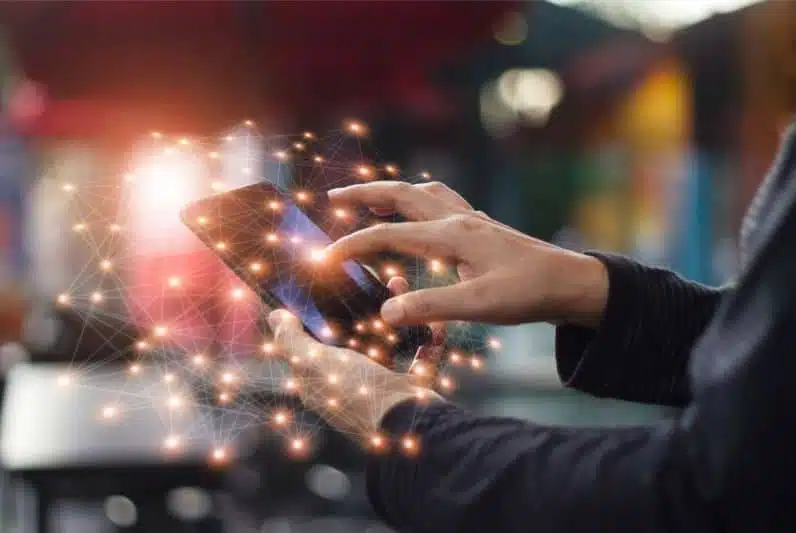 Main tenant un smartphone connecté à un réseau de données Main tenant un smartphone connecté à un réseau de données