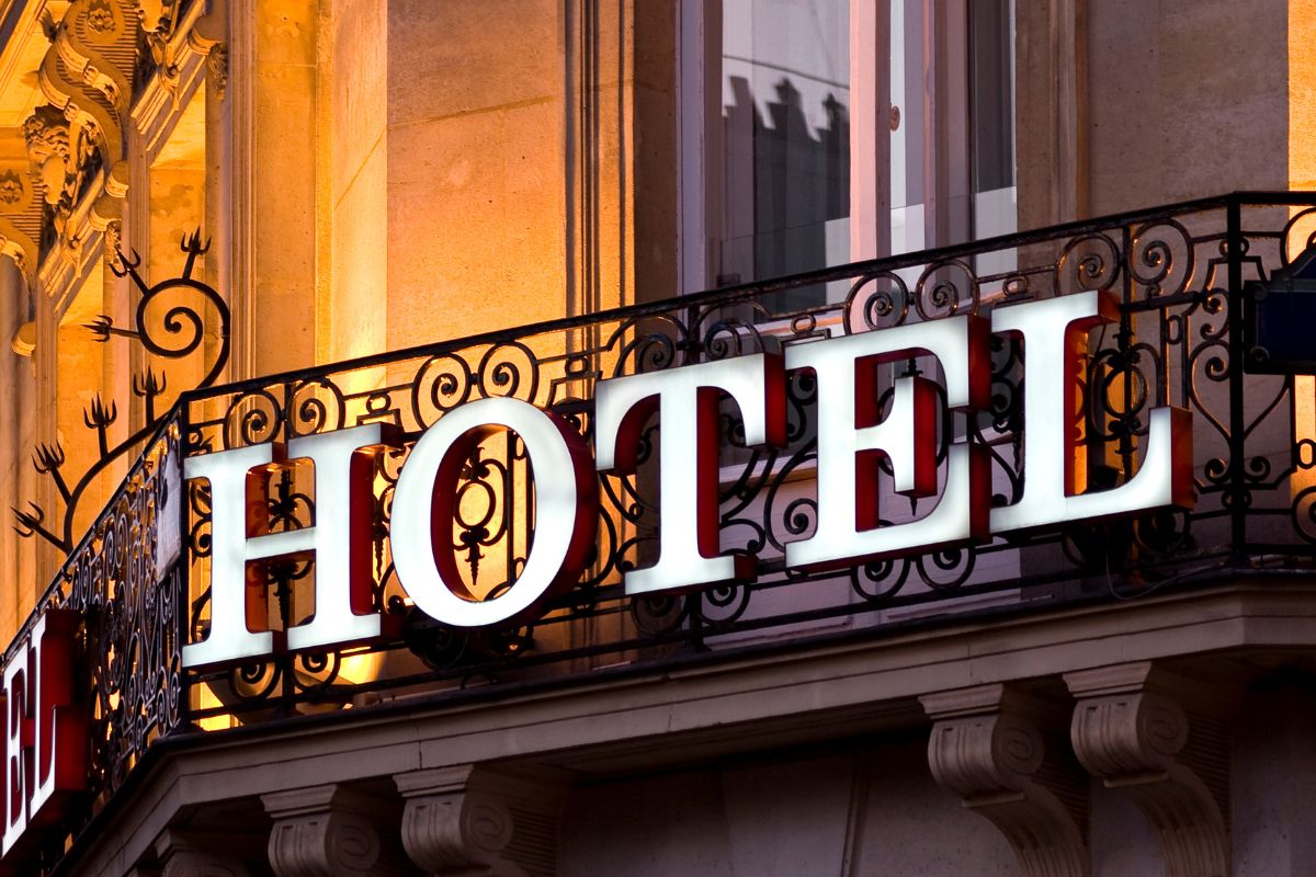Lettres lumineuses formant le mot hôtel sur le balcon en fer forgé d'un smart hôtel 